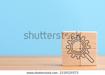Wooden cubes on gray background with seo cogwheel gear magnifying glass magnifier, Search Engine Optimization ranking concept. Digital marketing strategy of promote traffic to website