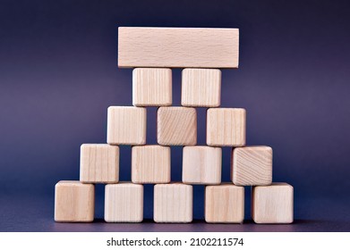 Wooden cubes stacked with a pyramid on a blue-purple background