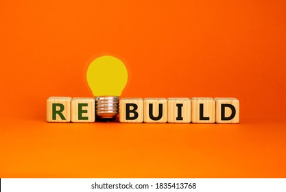 Wooden cubes with word 'rebuild'. Yellow light bulb. Beautiful orange background. Business concept. Copy space.