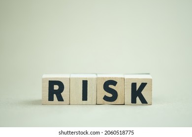 Wooden Cubes With The Word Risk. Risk Taking, Risk Management Or Assessment Concept. Eliminate Risk In Business Finance Decisions.