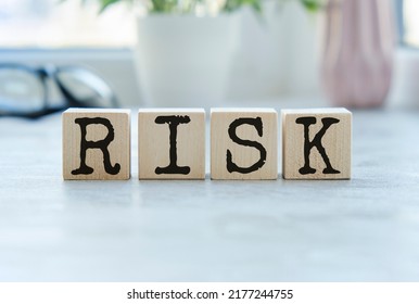 Wooden Cubes With The Word Risk. Risk Taking, Risk Management Or Assessment Concept. Eliminate Risk In Business Finance Decisions.