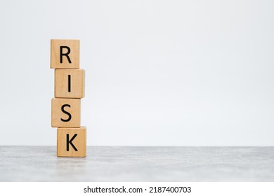 Wooden Cubes With The Word Risk. Risk Taking, Risk Management Or Assessment Concept. Eliminate Risk In Business Finance Decisions.