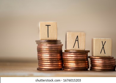 Wooden cubes with the word Tax on money climbing staits, pile of coins ,Tax Concept background closeup