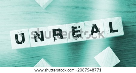 Wooden cubes with the word unreal on wooden background. Facts and figusres true and lies concept