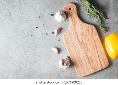 Wooden Cutting Board with Fresh Herbs and Raw Vegetables on Rustic Wood Table. Top view. Cooking background. 