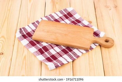 Wooden cutting board on a napkin on a wooden table