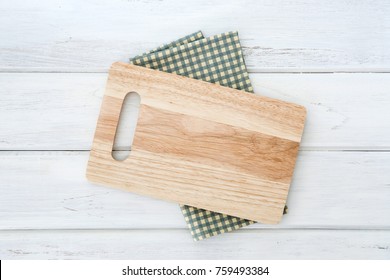 Wooden Cutting Board On Napkin Placed On White Wooden Table ,top View Or Overhead Shot , Food Menu Card Or Recipes Background Concept