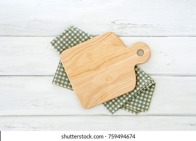 Wooden Cutting Board On Napkin Placed On White Wooden Table ,top View Or Overhead Shot , Food Menu Card Or Recipes Background Concept