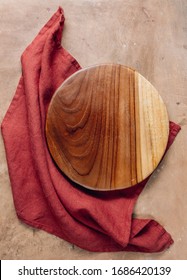 Wooden Cutting Board Over Towel On Beige Rustic Kitchen Table. Space For Your Recipe Or Menu. Top View.