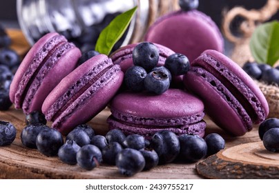 A wooden cutting board showcasing a vibrant display of purple macarons and blueberries, highlighting the natural foods and colorful ingredients used in creative culinary art
