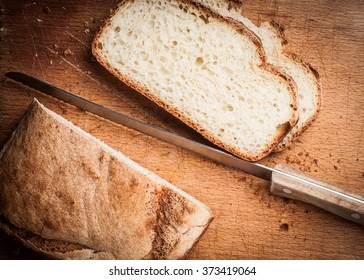 Wooden Cutting Board With Sliced White Bread And Knife On Wooden Table