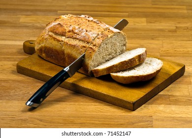 Wooden Cutting Board With Sliced White Bread And Knife On Wooden Table