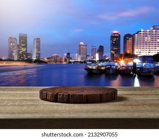 Wooden cuttingboard on wooden table for standing product against cityscape