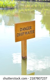 Wooden DANGER DEEP WATER sign in middle of lake. - Shutterstock ID 2187807237