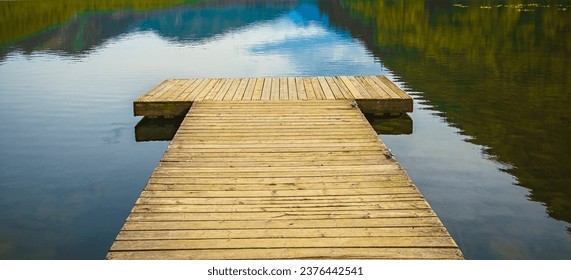 Wooden deck on the forest lake in summer. Lake for fishing with pier. Wooden pier on the waterfront with mountain scenery background in the early morning. Morning summer landscape at the Dear Lake BC - Powered by Shutterstock