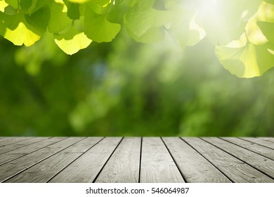 Wooden desk and blur green nature background.