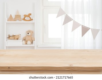 Wooden desk on blurred child room or kindergarten interior background