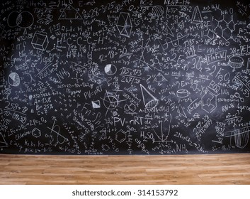 Wooden Desk With School Supplies In Front Of Big Blackboard