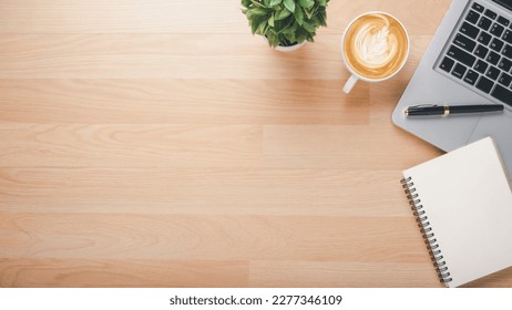 Wooden desk workplace with laptop computer, notebook, pen and cup of coffee, Top view flat lay with copy space. - Powered by Shutterstock