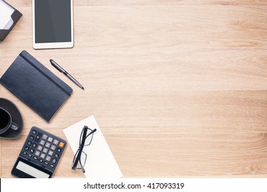 Wooden desktop with office tools on its left side. Topview, Mock up - Powered by Shutterstock