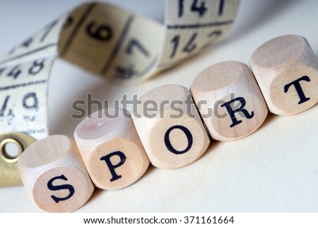 Wooden dice with the word sport and tape measure / Sport