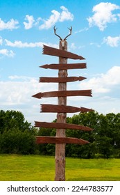 Wooden Direction Sign. Empty wooden direction sign. A wooden direction sign with a horned deer skull on top. - Shutterstock ID 2244783577
