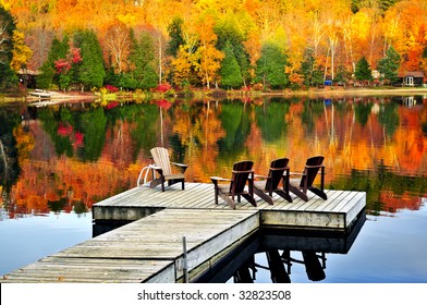 Wooden Dock With Chairs On Calm Fall Lake