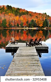 Wooden Dock With Chairs On Calm Fall Lake