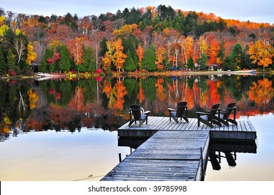 Wooden Dock With Chairs On Calm Fall Lake