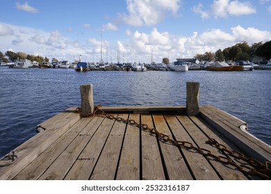 Wooden dock at a marina filled with boats in the summer - Powered by Shutterstock