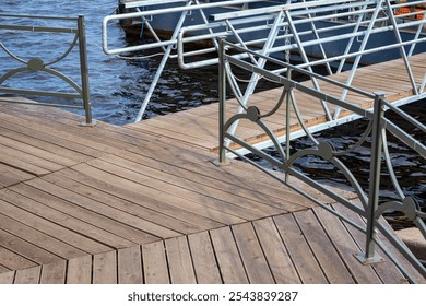 A wooden dock with a metal railing. The railing is ornate and the dock is made of wood. - Powered by Shutterstock