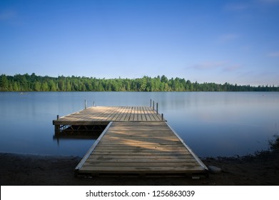 Wooden dock on a calm lake at the cottage in Ontario, Canada.