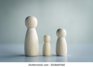 Wooden Doll Family On The Table And Gray Background.
