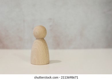 Wooden doll, figure standing infron tof the old wall, peg doll, natural wood