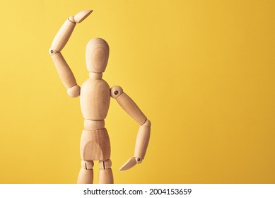 Wooden doll with gesture on yellow background. Mannequin shows gesture. Figure of wooden human with copy space - Powered by Shutterstock