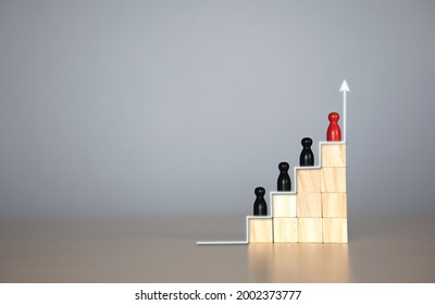 wooden doll in a hierarchy of wooden blocks. The concept of raising the level of individuals in the organization,  Leadership,  teamwork. with copy space for text or design concept for business 