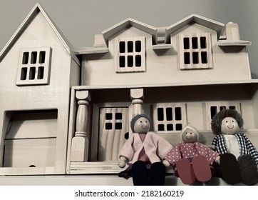 Wooden Doll House And Three Dolls