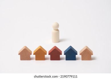 The Wooden Doll And A Miniature Houses In White Background