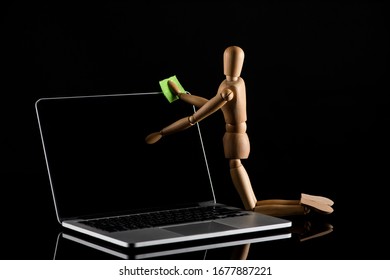 Wooden doll on knees position imitating dusting laptop on black - Powered by Shutterstock