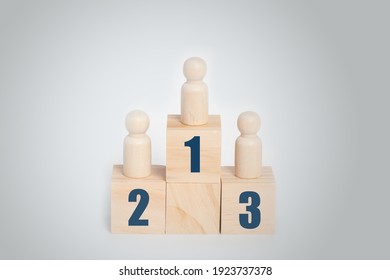 Wooden Doll Standing On Podium 1, 2, 3 Of Wooden Building Blocks, Business Hierarchy, Ranking And Strategy Concept. 