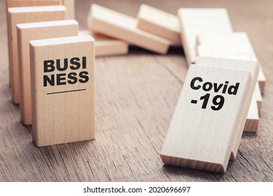 Wooden domino on the table filled with text: Covid-19 and Business, the upcoming impact of Covid-19 on business, market, and supply chain