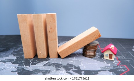 Wooden Dominoes Fall On A Pile Of Coins With House On Global Map. Business Concept Of Domino Effect Within Unaffordable Housing Market.  Economic Collapse Or Financial Crisis From Coronavirus Impact.