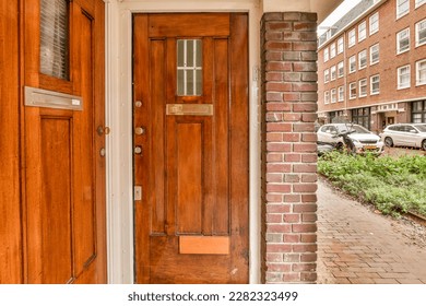 a wooden door in front of a brick building with a car parked on the side walk way next to it - Powered by Shutterstock