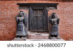 Wooden door and guards outside Old Palace of Bhaktapur Durbar Square, Kathmandu, Nepal.