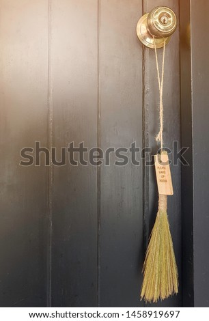 Wooden door of hotel room with please make up the room tag made of broom grass, hemp rope and wood hang on old brass door knob.Hotel service. Selective focus. Copy space.