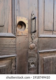 Wooden door with old locks. One of the locks was removed and the metal plate remained.