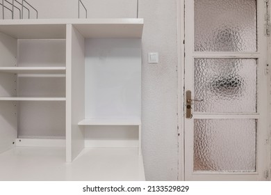 Wooden Door With Opaque Glass Next To White Wooden Shelves