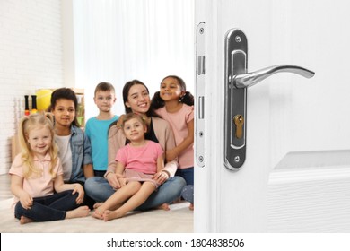 Wooden Door Open Into Modern Classroom With Teacher And Children