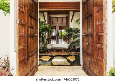 Wooden doors, beautiful Luxury villa Enter with natural decor, stones, water and plants 