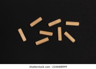 Wooden Dowel Pins On Black Background.